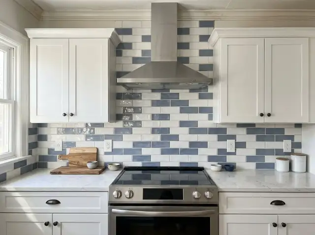 White and navy brick-pattern tile backsplash between white cabinets and a light countertop