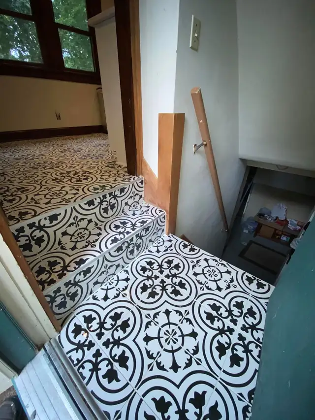 Black and white patterned floor tile running through a small room and doorway